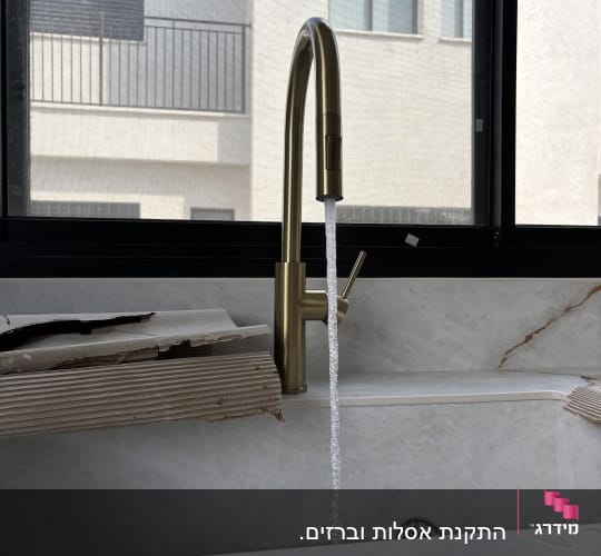 ברז מים זורם בכיור עם רקע חלון